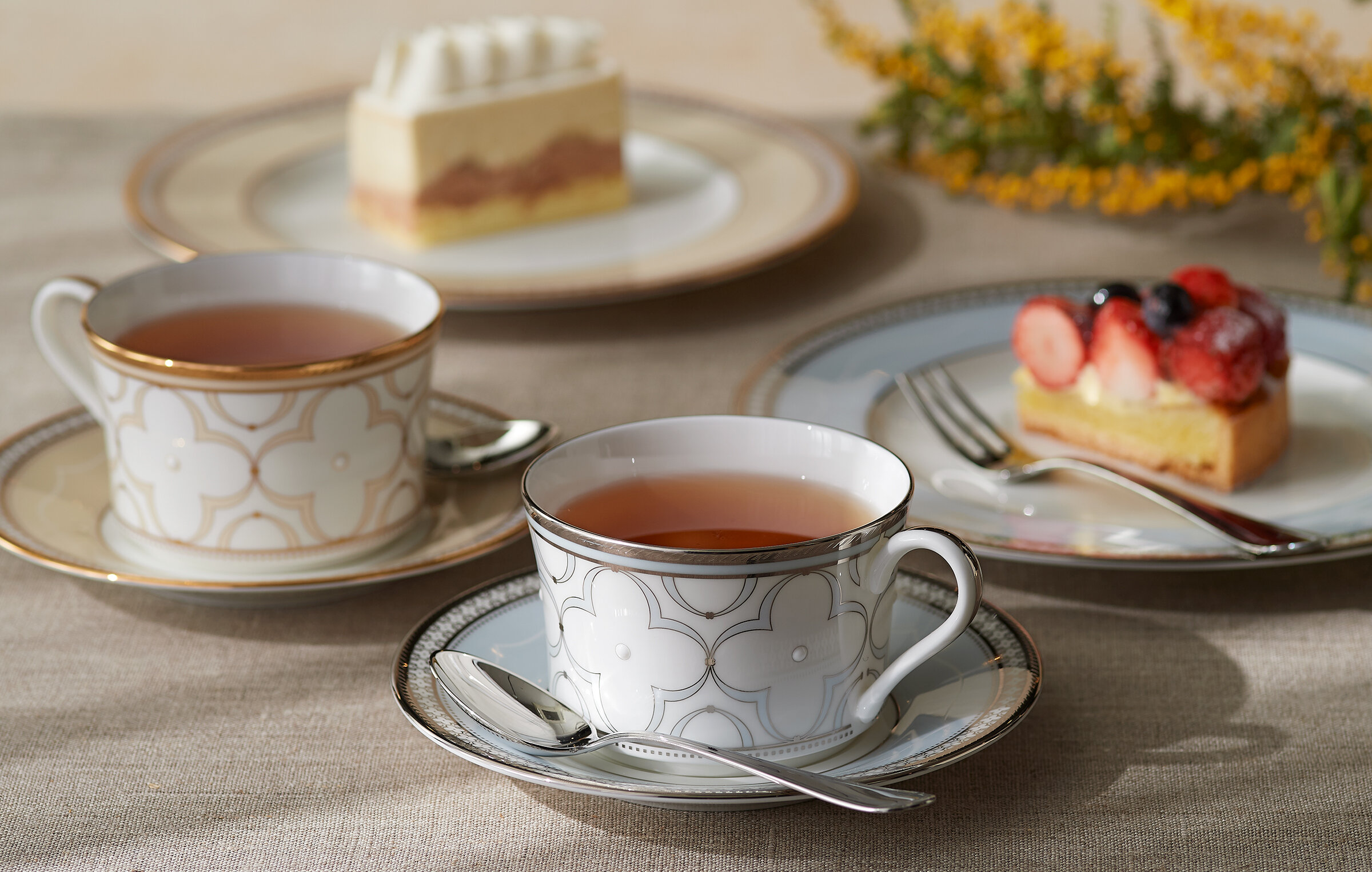紅茶を注いだカップとスイーツを楽しむ、ノリタケのティーテーブル